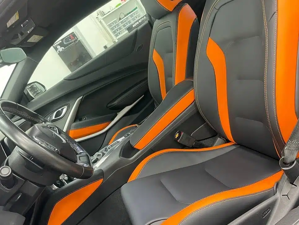 Chevrolet Camaro — салон с переднего пассажирского места: передние кресла и центральная консоль в чёрно-оранжевой экокоже с контрастной строчкой