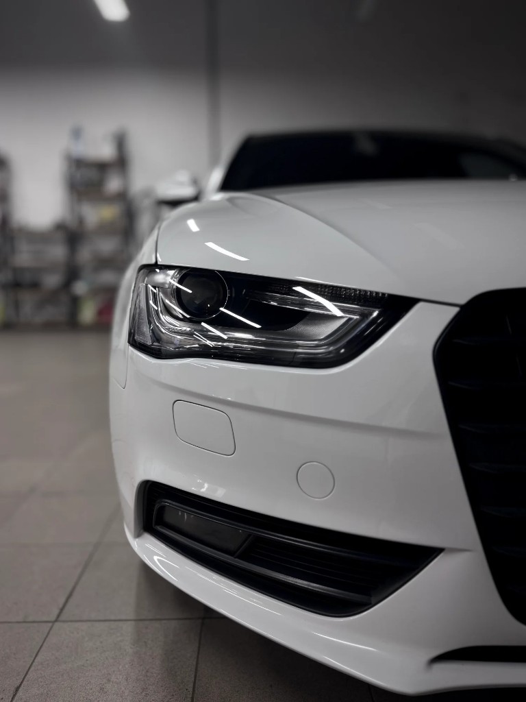 Замена стекла фары белого Audi — результат работ в студии Auto Style